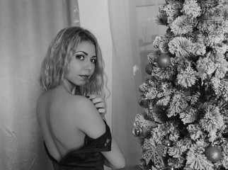 beautiful girl in black dress Christmas tree , open back, black white.