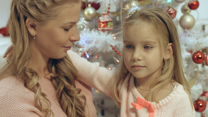 Mother hugs her little daughter in a Christmas atmosphere