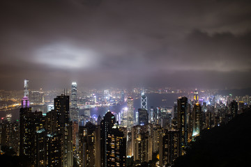 Hong Kong, China skyline panorama from across Victoria Harbor. Hong Kong city skyline view from harbor with skyscrapers buildings reflect in water at sunset