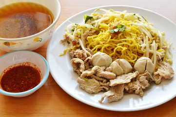 Chinese egg noodle topping boiled pork and soup with cayenne pepper sauce