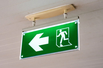 old Green fire exit sign at hotel.