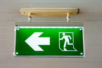old Green fire exit sign at hotel.