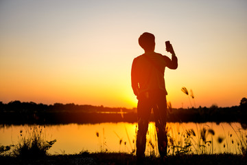 Fototapeta premium silhouette man relax on beautiful sunset background