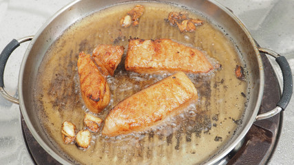 Pork fried cooking with palm oil in pan on gas stove