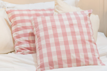 baby pink plaid pillow on white mattress