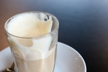 Empty cup of the latte art coffee on the black table with copy space