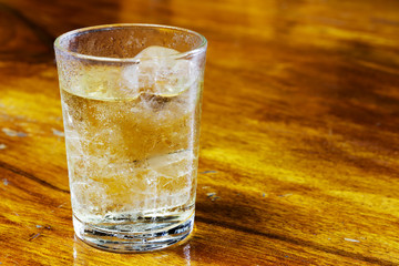 Drinking water in the glass on a wooden table.