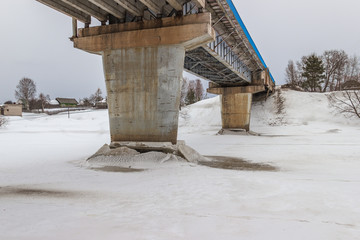 The supports of the bridge over the river Mologa. Winter. Ice.