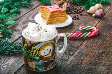 Coffee with marshmallow, candy  and cake on christmas decoration.