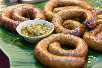 northern thai style sausages served with chili paste dip on banana leaf