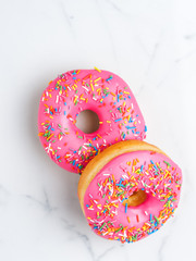 Tasty donuts with raspberry on white background