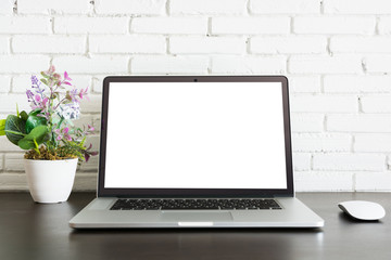 Fototapeta premium Laptop mouse and flowers vase on table with white background
