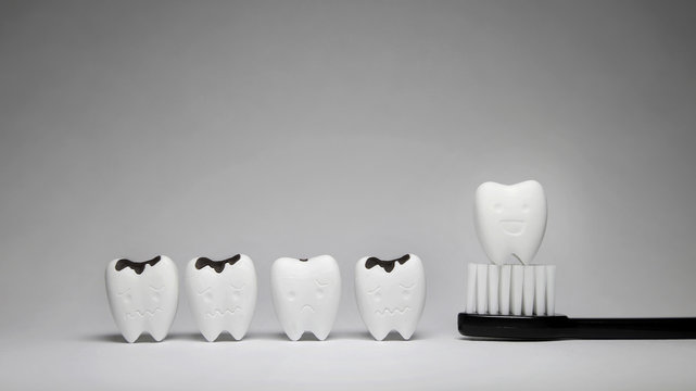 Decayed tooth and Tooth model in happy emotion on black toothbrush, if brush the teeth, teeth will good healthy 2