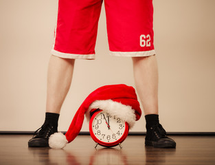 Closeup of man with alarm clock. Christmas time.