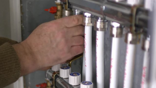 Footage of a plumber working on a central heating system in a new home