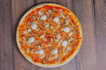 Top view of pizza with mushrooms and mayonnaise sause cutted on