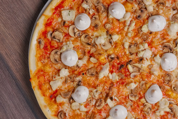 Top view of pizza with mushrooms and mayonnaise sause cutted on