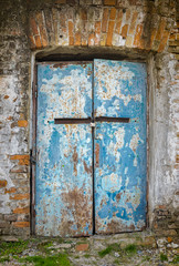 Old architectural details - door in an ancient building locked with small rusty padlock