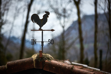 Rusty weathercock  on top of a roof
