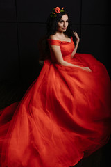 Fototapeta premium beautiful woman in the luxurious red dress on a black background