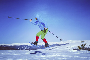 Winter hiking in the mountains on snowshoes with a backpack and