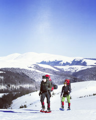 Winter hiking in the mountains on snowshoes with a backpack and