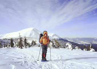 Winter hiking in the mountains on snowshoes with a backpack and