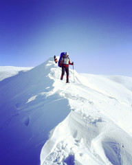 Winter hiking in the mountains on snowshoes with a backpack and