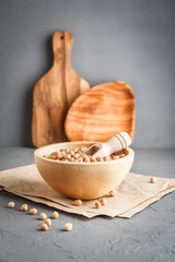 Chickpeas in a wooden bowl on gray background