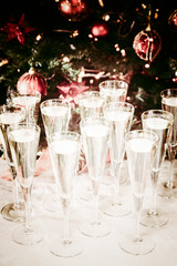 Glasses of champagne with Christmas tree background. Many glasse