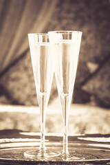 Two champagne glasses with oriental canopy bed at the background