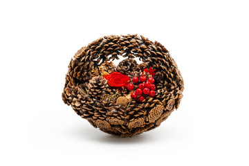 A basket of pine cones with Holly berries and red flowers