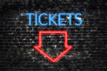 Tickets neon sign on dark brick wall background