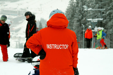 Snowboard instructor. Teaches snowboarding beginner. Rookie crashes but continues to learn.