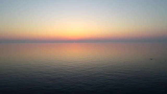 Tramonto sul mare calmo a Lesbos con barca all'ancora ripresa dal drone