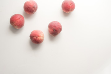 High angle view of five white peaches scattered on table