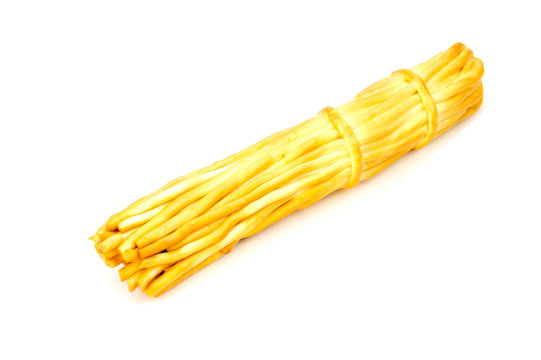 Smoked chechil cheese in the form of strings rolled up in a figure of braided shaped ropes on a light background