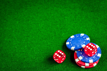 poker chips and dice on green background top view