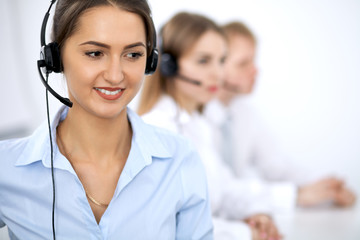 Call center. Focus on beautiful woman in headset