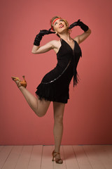 Pretty actress in black retro dress dancing charleston