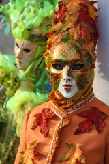 Portrait of Venice masked man orange and green