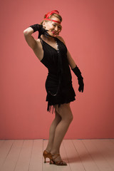 Pretty actress in black retro dress dancing charleston