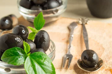 Foto op Plexiglas Black olives with green leaves with vintage flatware © romensky