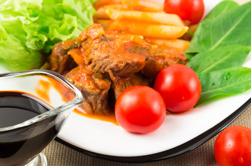 View close-up on a meal of beef stew with pasta penne nad herbs