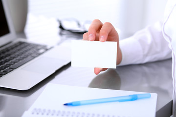 Close-up of business woman giving a visit card