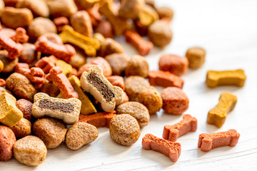 dry dog food in bulk on wooden background close up
