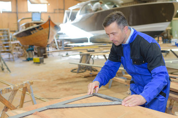 shipwright measuring the plywood