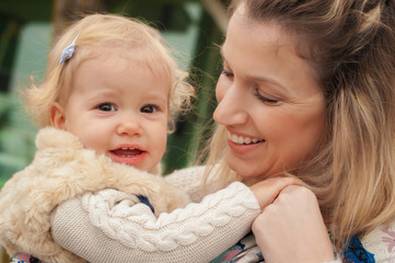 Obraz premium Young mother having her little daughter in baby carrier scarf