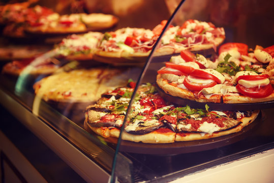 True Italian Pizza In The Showcase Of Pizzeria In Florence, Italy. Food Background.