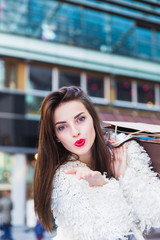 Obraz premium Portrait of beautiful young brunette woman with shopping bags outdoors